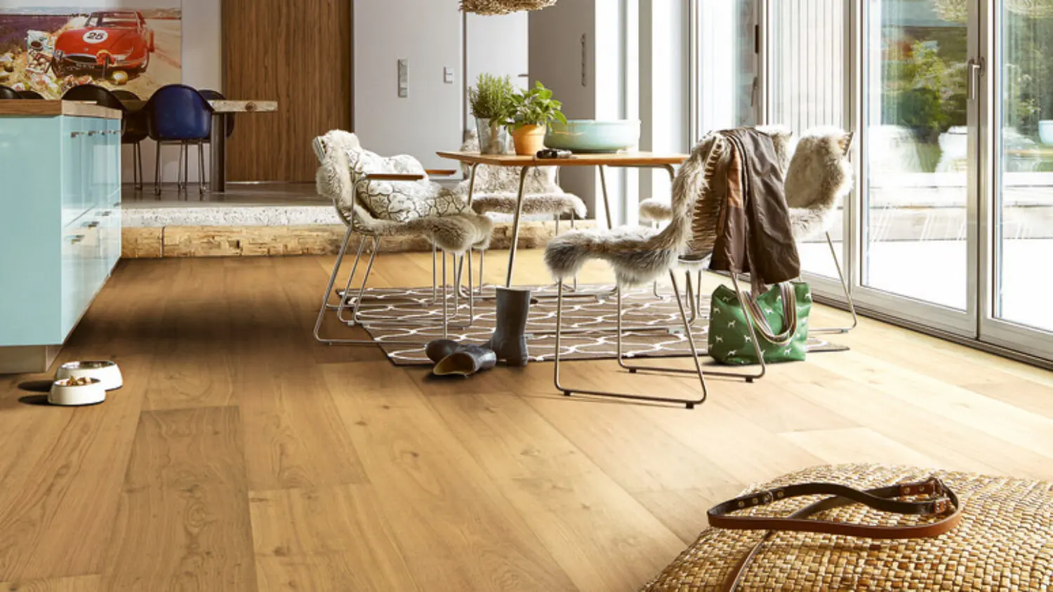 Verlegter Parkett von Blickfang Elemente im Wohnraum mit Tisch und Küchenzeile und Glastüren zur Terrasse