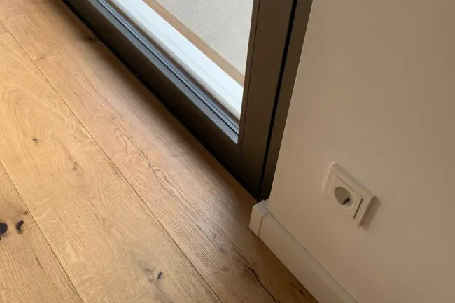 Nahaufnahme eines Parkettbodens von Blickfang Elemente mit Tür zur Terrasse